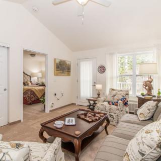 A cozy living room with comfortable sofas, a coffee table, and soft natural lighting.