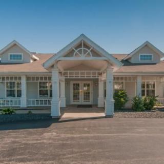 A front view of a residential house with a driveway and porch.