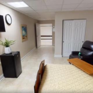 A minimalist room interior with a bed, chair, and wall decor.