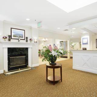 A welcoming lobby area with a reception desk, fireplace, and floral decor.