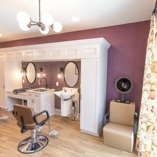 A modern beauty salon interior with styling stations and mirrors.
