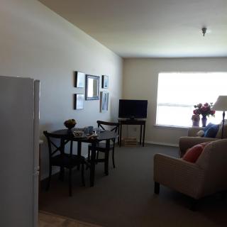 A cozy apartment living room with a small dining area and a television.
