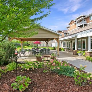 A peaceful garden patio area with outdoor seating and lush landscaping.