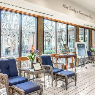 A bright and welcoming waiting area with comfortable seating and natural light streaming through large windows.