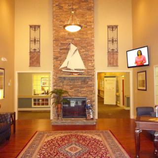 A well-decorated lobby with a fireplace, decorative ship model, and comfortable seating.