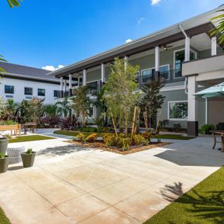 A modern building with a landscaped courtyard and clear blue sky.