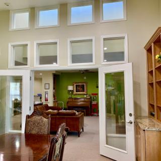 A spacious living area showcasing a blend of natural light and refreshing green decor.