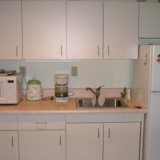 A kitchen with white cabinets, countertop appliances, and a sink.