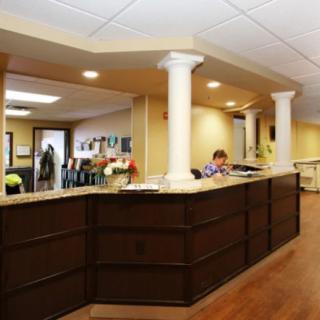 A reception desk in an office lobby with columns and overhead lighting.