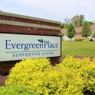 Sign for Evergreen Place Supportive Living in a landscaped outdoor setting.
