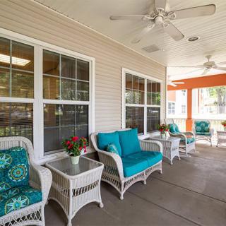A cozy patio area with wicker furniture and bright cushions, perfect for relaxation.
