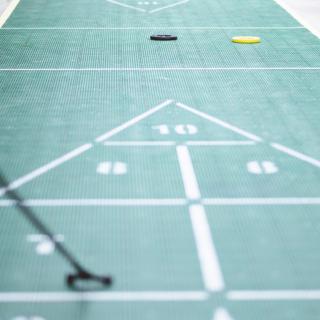 A shuffleboard court with discs and cues ready for play.