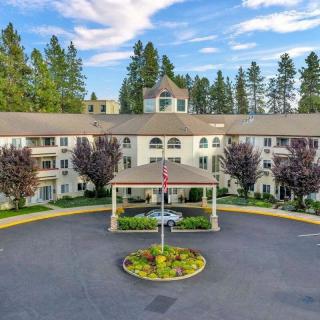 A spacious residential building with a circular driveway, surrounded by trees and landscaped gardens.