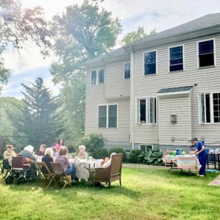 A cheerful gathering of friends and family enjoying a sunny day in the backyard.
