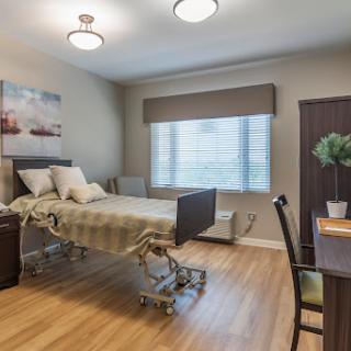 A well-lit hospital room featuring a patient bed, modern furnishings, and calming decor.