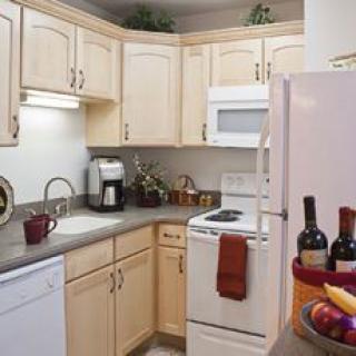 A cozy kitchen with light wood cabinets and modern appliances.