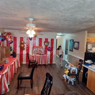 A vibrant indoor carnival-themed party setup with colorful decorations and a playful atmosphere.