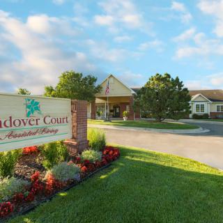 A welcoming entrance with a landscaped garden and a sign for Andover Court, set against a cloudy sky.