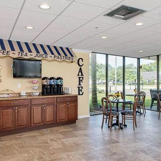 A cozy cafe interior with a coffee station, seating, and large windows providing natural light.