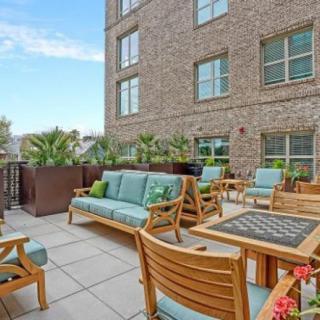 A cozy patio area with wooden furniture and lush greenery in an urban setting.