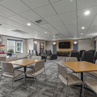 A modern lounge area featuring tables and chairs, designed for relaxation and social gatherings.