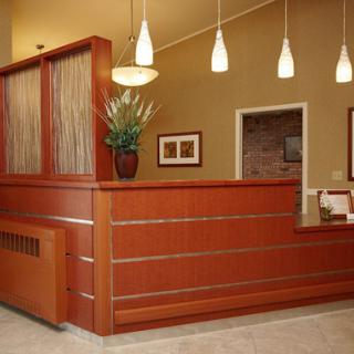 A modern reception area featuring wooden furniture and contemporary lighting.