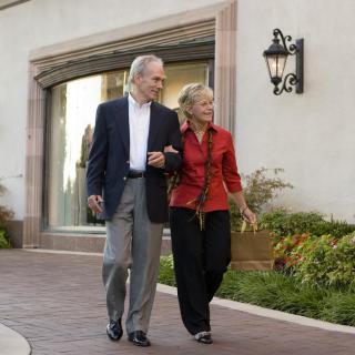 A senior couple walking together in a shopping area.