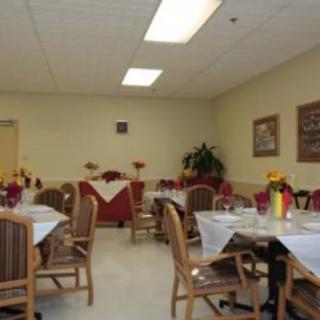 A neatly arranged dining area with tables and chairs, adorned with simple decorations.