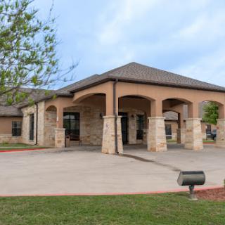 A modern architectural structure with a welcoming entrance and surrounding greenery.