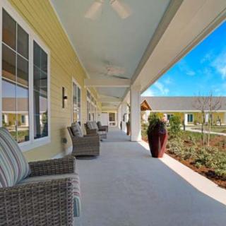 A spacious porch with comfortable seating overlooking a landscaped garden.