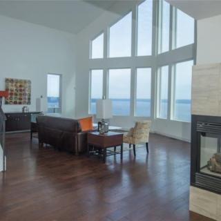 A modern living room with large windows offering a stunning ocean view.