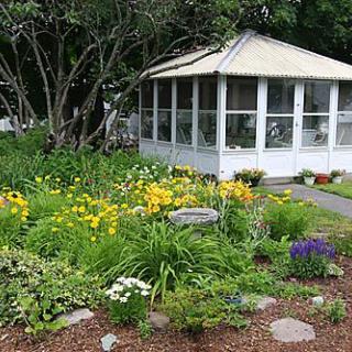 A lush garden with vibrant flowers in front of a gazebo.