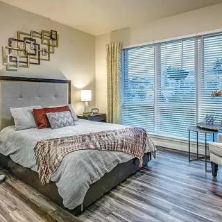 A modern bedroom with stylish decor and a large window, featuring a comfortable bed and elegant furnishings.