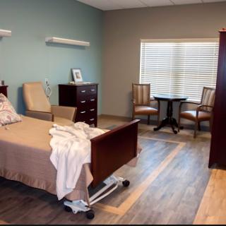 A well-designed hospital room featuring a bed, dresser, and seating area.