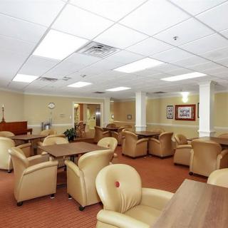 A spacious lounge area with comfortable seating and tables, well-lit with overhead lights.