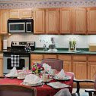 A well-organized kitchen with a dining table elegantly set for a meal.