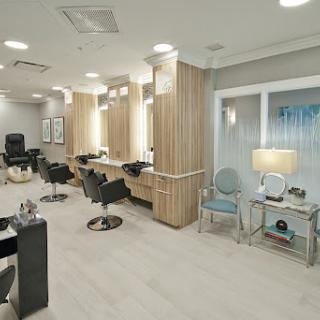 A modern hair salon featuring elegant chairs and well-designed lighting.