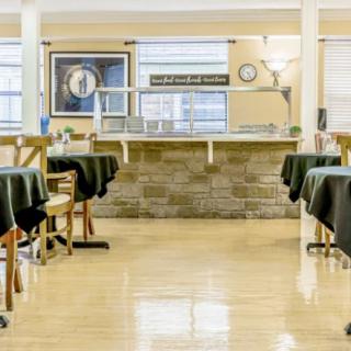 An empty dining area with neatly arranged tables and chairs, ready for service.