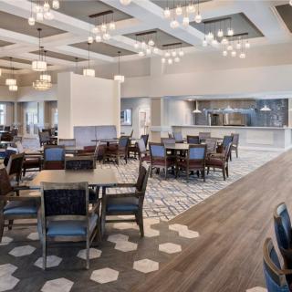 A spacious modern dining area with elegant seating and lighting.