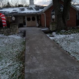 A cozy house adorned with winter decorations, surrounded by a light dusting of snow.