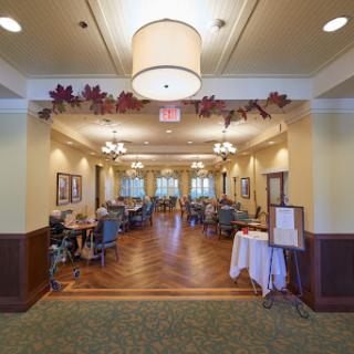 A welcoming dining area adorned with decorative leaves and warm lighting, featuring comfortable seating and a cozy ambiance.
