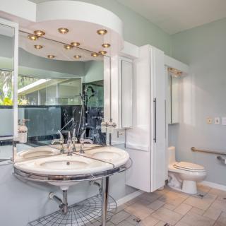 A modern bathroom with a stylish vanity, large mirror, and tiled flooring.