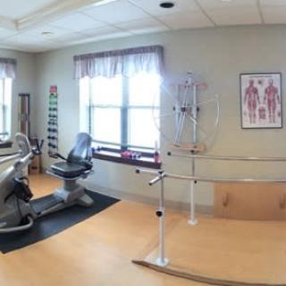A spacious physical therapy room equipped with exercise machines and therapy tools.