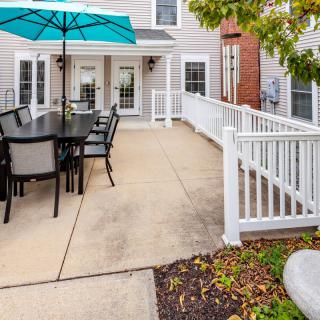 A cozy backyard patio with a dining table, chairs, and an umbrella.