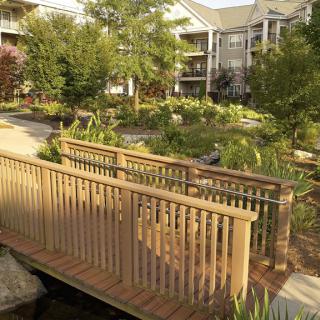 A tranquil garden scene with a wooden bridge at an apartment complex.