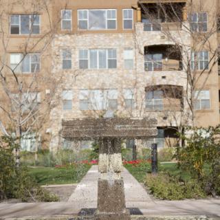 A courtyard with a fountain in front of a residential apartment building.
