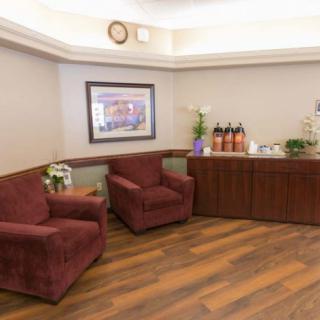 A cozy waiting room with comfortable chairs and a refreshment table.