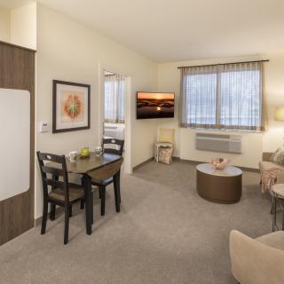 A cozy apartment living room with a small dining area and modern decor.