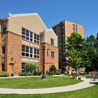 A view of a campus building with a landscaped garden and pathway.