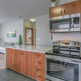 A modern kitchen featuring sleek appliances and a wooden countertop.